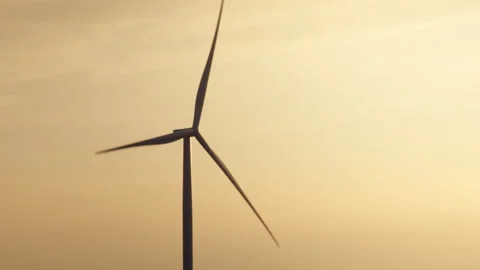 Close-Up View of a Wind Turbine at Sunset with Golden Sky Stock Footage 296931089