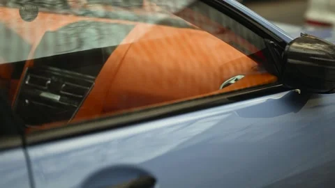A close up view of the window of a luxury sport car with a vibrant orange i.. Stock Footage 339408757