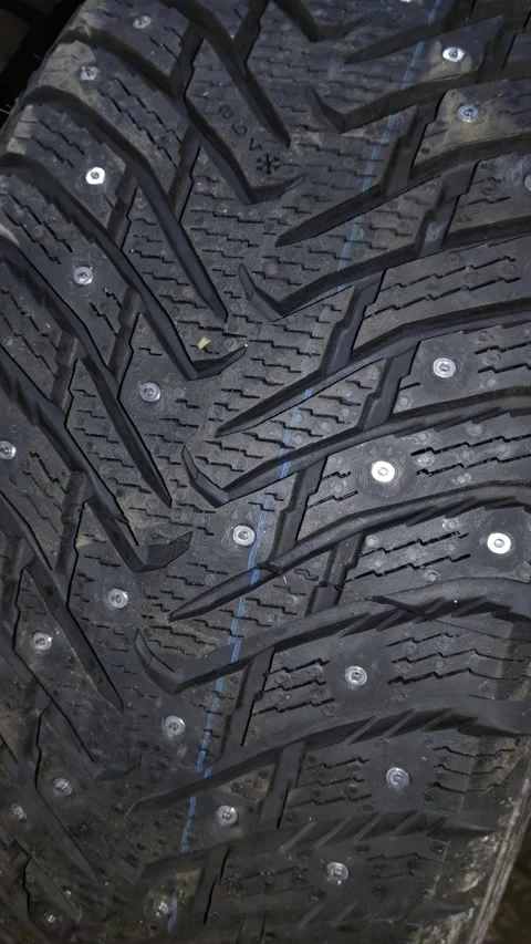Close-up view of winter tire tread pattern featuring snowflake symbol Stock Footage 346638418