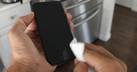 Close up view of woman hand using antibacterial wet wipe for disinfecting phone Stock Footage 126948154