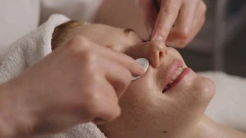Close-up view of woman smiling while receiving facial massage using white Stock Footage 236849784