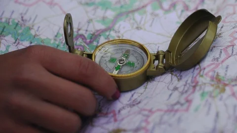 Close up view of woman using compass and map on the background. Girl holding a Video stock 108732127