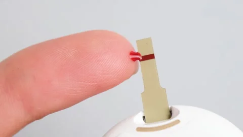 Close up view on woman using glucometer and checking blood sugar level. Diabetes Stock Footage 256056709