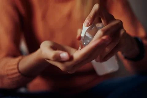 Close up view of woman using small portable antibacterial hand sanitizer on Stock Photos