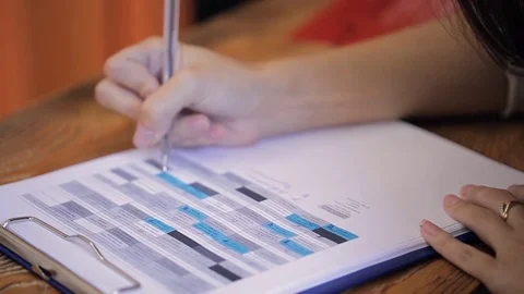 Close up view of woman working with table printed in paper Stock Footage 71961845