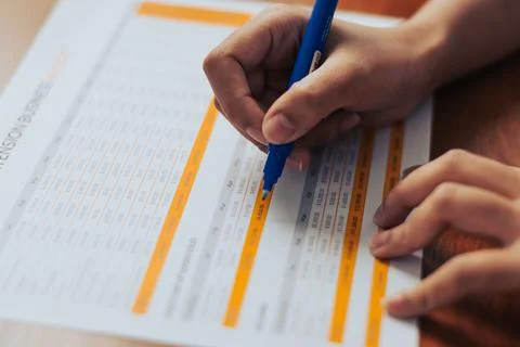 Close up view of a womans hand elegantly writing on a business document usi.. Stock Photos