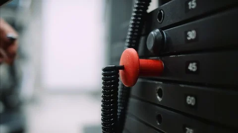 Close view of woman's hand increasing weight on lat pull workout machine Stock-Footage 126670482