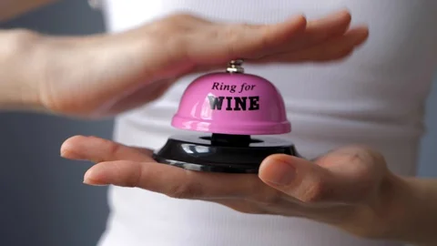 Close up view of woman's hand ringing the pink bell. Stock Footage 128906469