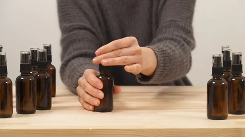 A close-up view of the woman's hand taking one of the bottles with dispenser Stock Footage 103142241