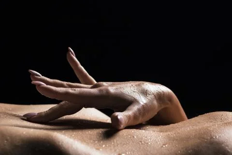 Close-up view of woman's hand touching her belly. Stock Photos