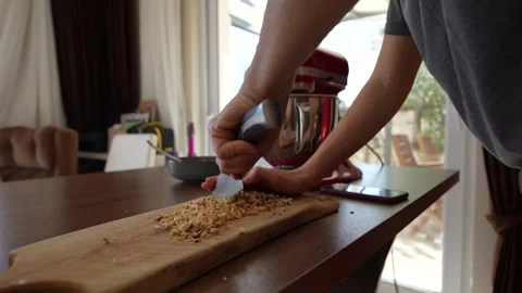 Close-up view of woman's hands chopping nuts with knife on board. Stock Footage 254918508