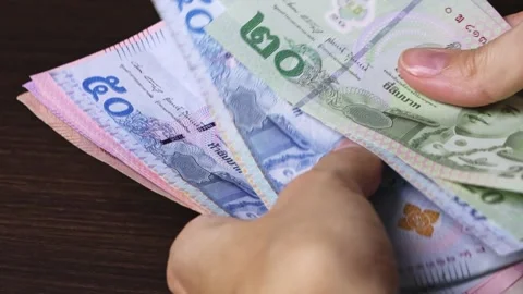Close up view of woman's hands counting Thailand currency notes Stock Footage 304284714