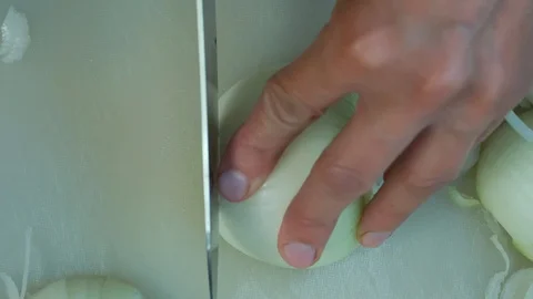 Close-up view of woman's hands is cutting onion on cutting board Stock Footage 114875349