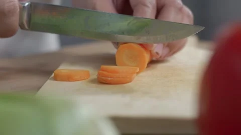 Close up view of woman's hands cutting carrots on a cutting board over a wo.. Stock Footage 329702956