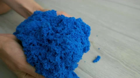 Close-up view of woman's hands with kinetic sand of bright blue color. Stock Footage 168609522