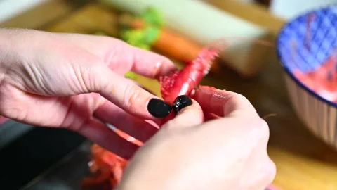 Close up view of woman's hands peeling cleaning red raw  shrimps in kitchen Stock Footage 165923315