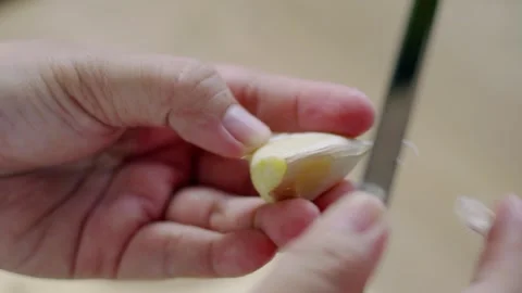 Close up view of woman's hands peeling garlic with a knife, preparing ingre.. Stock Footage 329703420