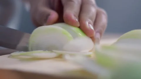 Close up view of Woman's hands slicing onion with a knife on wooden cutting.. Stock Footage 329702959