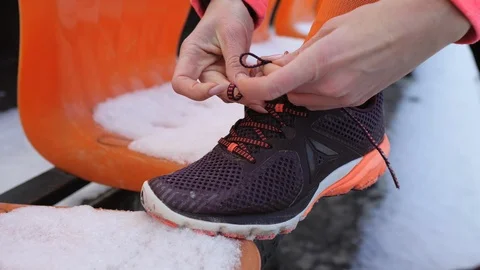 Close up view of woman's hands tie shoelaces on her sneakers. Video stock 124467938
