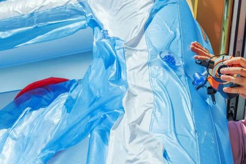 Close-up view of a woman’s hands using an electric pump to inflate a pool Stock Photos