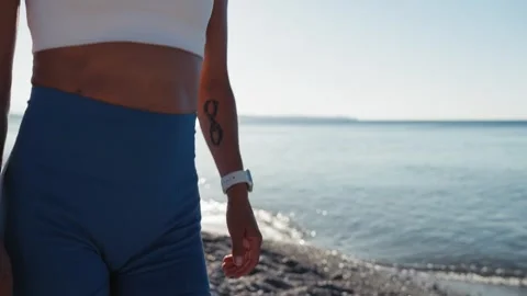 Close-up view of woman's legs walking on the pebble beach. Stock Footage 245724216