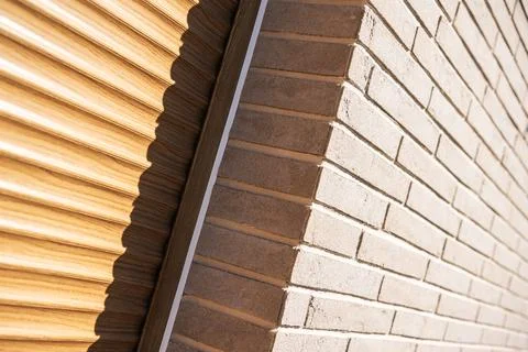 Close view of a wood effect roller shutter beside brick cladding Photos