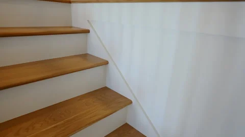 Close view of wooden staircase steps with white wall inside a residential home. Video stock 331024937