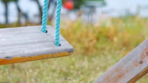 A close-up view of a wooden swing gently moving in slow motion 60fps Stock Footage 290097317