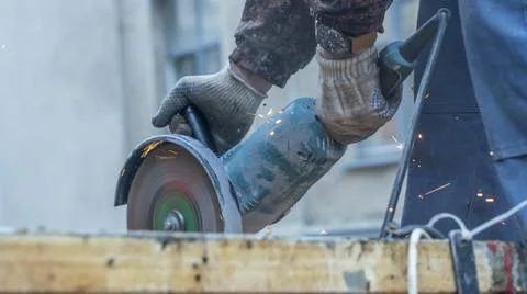 Close-up view of a worker working with angle grinder. Electric wheel grinding Stock Photos