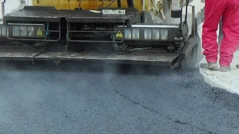 Close view on the workers and the asphalting machines. The heat of the burned Stock-Footage 153905902
