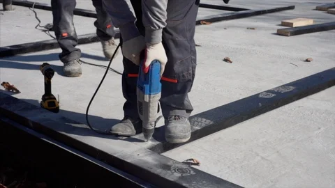 Close view: workers are using electric drill and screw gun. House constrtuction Video stock 119668780