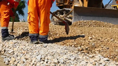 Close-up view on workers using shovels for realign excess of fraction Stock Footage 154532662