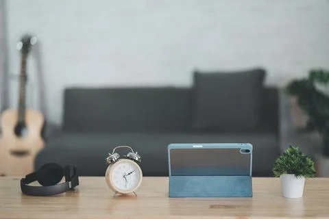 Close up view of worktable with tablet,  headphone, clock, acoustic guitar an Foto stock