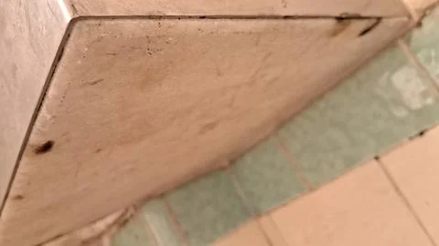 Close up view of worn beige stone tiles and floor grout Stock Photos