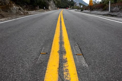 Close-up view of a worn yellow double line on the road Stock Photos