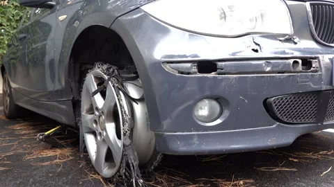 A close up view of a wrecked car with a shredded tire revealing the rim and.. Stock Footage 339763826
