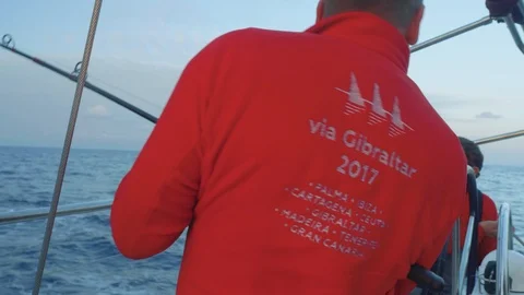 Close up view of yachtsman in red coat pulling fishing pole from water and other Stock Footage 93274476
