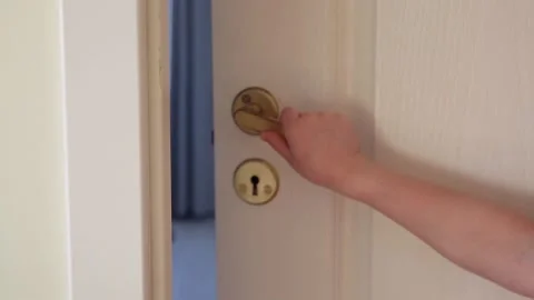 Close up view of young 6 year old girl child opening slowly home door handle. Stock Footage 149313813