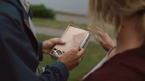 Close-up view of young attractive couple opening the box with present, take out Stock Footage