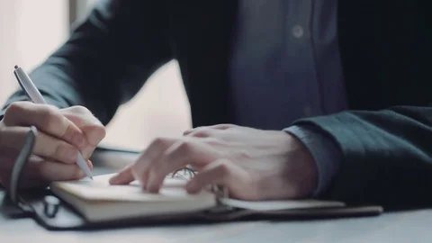 Close up view of a young businessman talking on the phone, and taking notes. Video stock 74808031