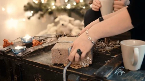 Close-up view of young couple sitting at the table and tie ribbon on present Stock Footage