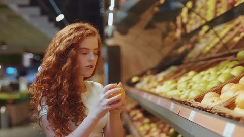 Close up view of young curly redheaded Caucasian student girl choosing fresh Stock Footage 114251105