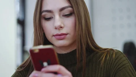 Close up view of a young female using the phone while sitting in a cozy cafe Video stock 77045117