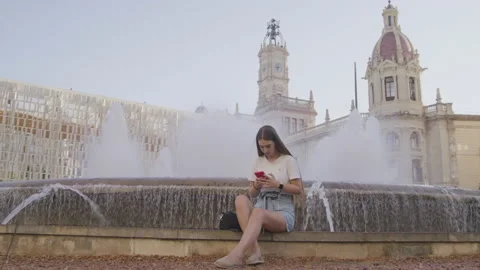 Close-up view of a young girl using her smartphone while sitting on stairs Stock Footage 225615278