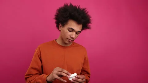 Close-up view of young guy in colorful clothes enjoying music and dancing Stock Footage 230695608
