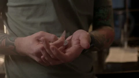 Close up view, young guy with tattoos on his arms takes pill from blister and Video stock 233545234