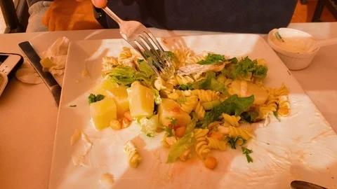 Close up view of young man eating a fresh salade in a restaurant Stock Footage 120136799