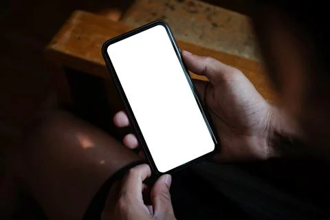Close up view young man hands holding smart phone empty screen while sitting  Foto stock