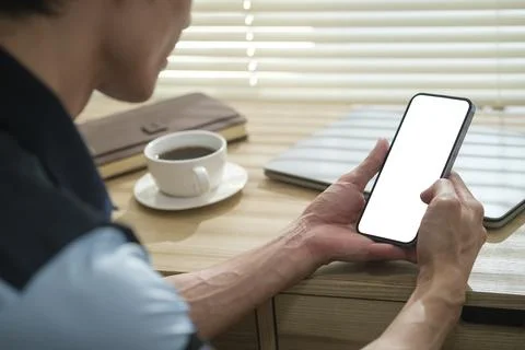 Close up view young man hands using smart phone while sitting in home office. Stock Photos