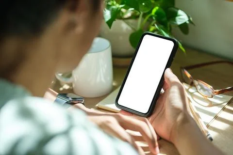 Close up view young man hands using smart phone while sitting in home office. Stock Photos